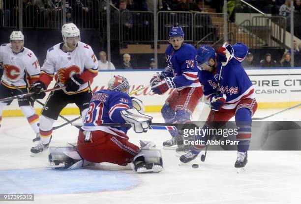 Ondrej Pavelec and Steven Kampfer of the New York Rangers defend the goal against the Calgary Flames during their game at Madison Square Garden on...