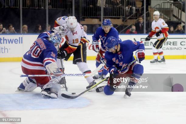 Henrik Lundqvist and Steven Kampfer of the New York Rangers defend the goal against the Calgary Flames during their game at Madison Square Garden on...