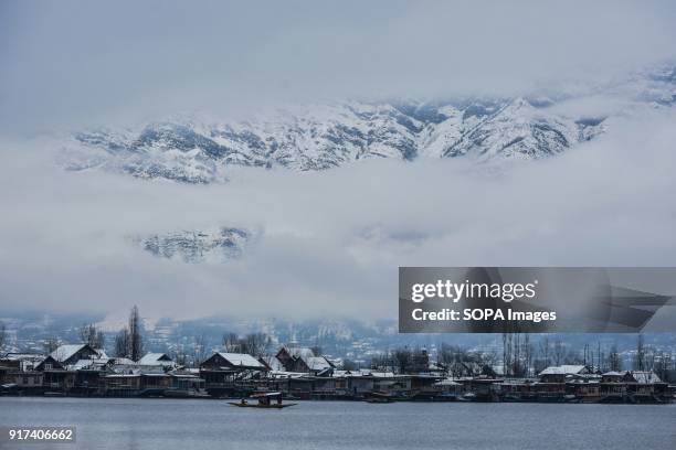 Shikara crosses the Dal Lake with the backdrop of snow covered mountains in Srinagar, Indian administered Kashmir. Moderate to heavy snowfall started...