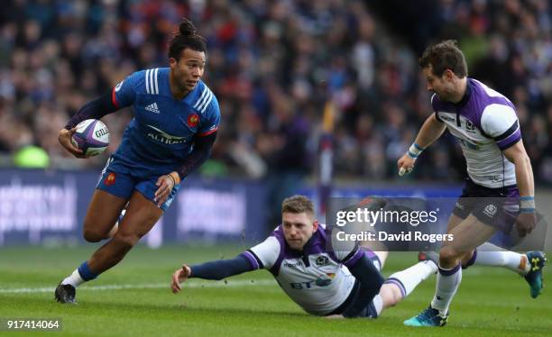 Teddy Thomas of France moves past Finn Russell and Pete Horne to score his first try during the Six Nations match between Scotland and France at...