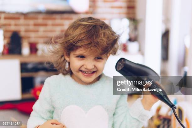 mother and little daughter have fun - hand holding hair dryer stock pictures, royalty-free photos & images