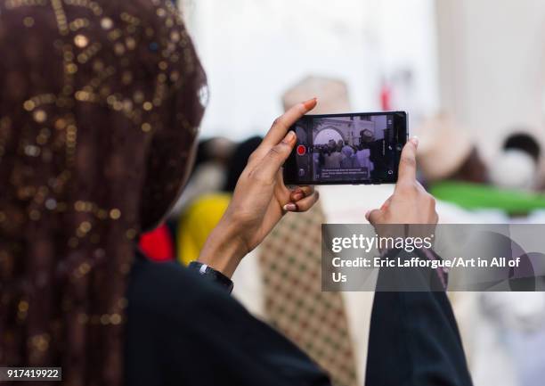 Sunni muslim woman taking pictures during the Maulidi festivities in the street, Lamu County, Lamu Town, Kenya on December 16, 2017 in Lamu Town,...