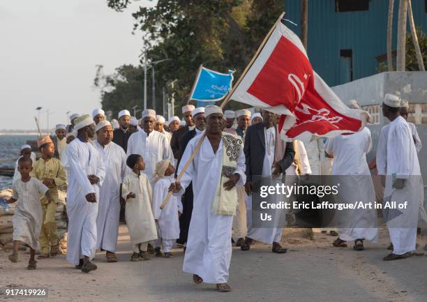 Sunni muslim people parading with flags during the Maulidi festivities in the street, Lamu County, Lamu Town, Kenya on December 15, 2017 in Lamu...