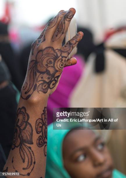 Sunni muslim woman with henna taking pictures during the Maulidi festivities in the street, Lamu County, Lamu Town, Kenya on December 16, 2017 in...