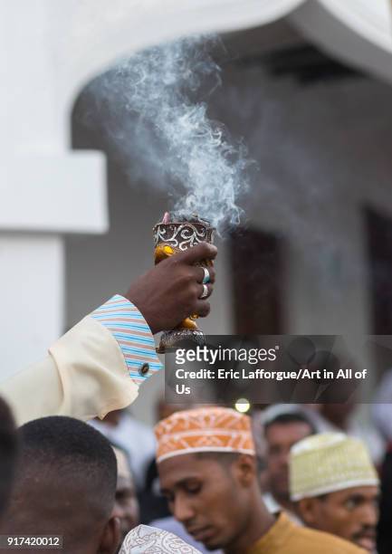 Sunni muslim man spreading insence with a censer during the Maulidi festivities in the street, Lamu County, Lamu Town, Kenya on December 16, 2017 in...