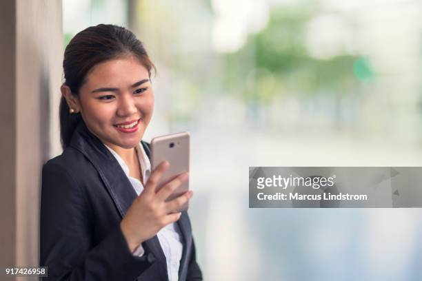 woman using a smart phone - philippines women stock pictures, royalty-free photos & images