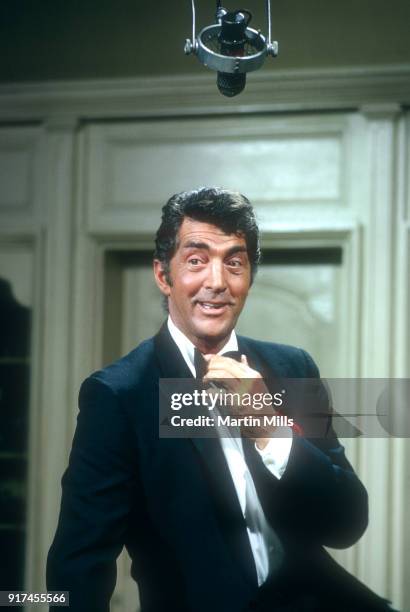 Entertainer Dean Martin adjusts his bow tie on the set of 'The Dean Martin Show' in 1967 in Los Angeles, California.