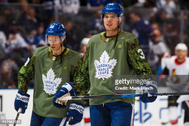 Auston Matthews of the Toronto Maple Leafs smiles while wearing a camouflage jersey to honour the Canadian Armed Forces during warm up before playing...