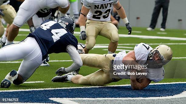 Fullback Vince Murray of Navy dives for a touchdown past defensive back Chris Jones of Rice at Rice Stadium on October 10, 2009 in Houston, Texas.