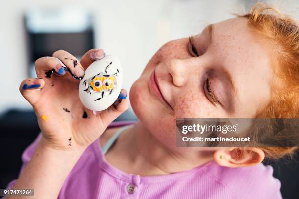 expressive preteen redhead girl crafting easter decorations at home. - dirty easter stock pictures, royalty-free photos & images