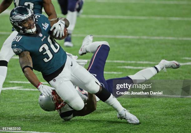 Corey Clement of the Philadelphia Eagles is tripped up by Patrick Chung of the New England Patriots during Super Bowl Lll at U.S. Bank Stadium on...