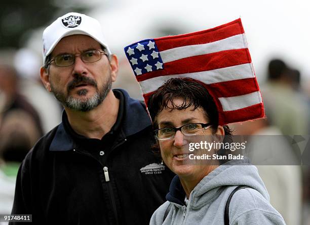 Two fans watch play during the day three Morning Foursome Matches of The Presidents Cup at Harding Park Golf Club on October 10, 2009 in San...