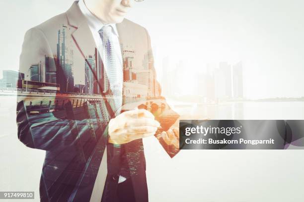 double exposure  businessman in suit writing in notepad on smartphone creative city background with copy space. men engineer taking notes - person in suit construction stock-fotos und bilder