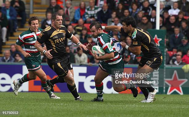 George Chuter of Leicester is tackled by Mike Phillips during the Heineken Cup match between Leicester Tigers and Ospreys at Welford Road on October...