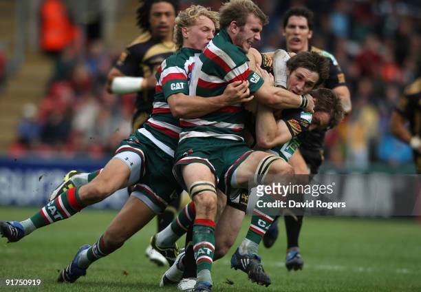 Andrew Bishop of the Ospreys is tackled by Tom Croft and Billy Twelvetrees and Johne Murphy during the Heineken Cup match between Leicester Tigers...