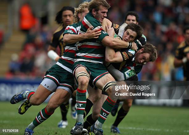 Andrew Bishop of the Ospreys is tackled by Tom Croft, Billy Twelvetrees and Johne Murphy during the Heineken Cup match between Leicester Tigers and...