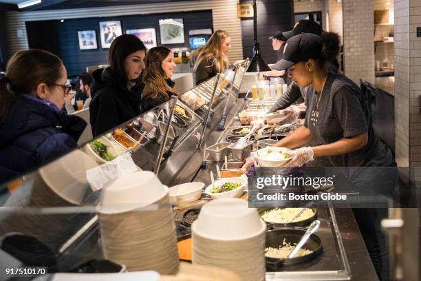 Diners are served by kitchen staff at Cava on Boylston Street in Boston on Feb. 6, 2018.