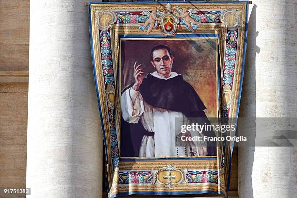 Tapestries featuring the portrait of new saint Francisco Coll Y Guitar hangs on a balcony overlooking the altar of St. Peter's Basilica during a...