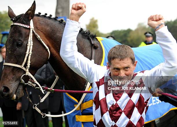 Czech jockey Josef Vana celebrates, next to his Polish horse Tiumen, after winning his sixth title at the 119th traditional Velka Pardubicka...