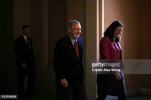 Senate Majority Leader Sen. Mitch McConnell walks towards the Senate chamber with an aide at the Capitol February 12, 2018 in Washington, DC. The...