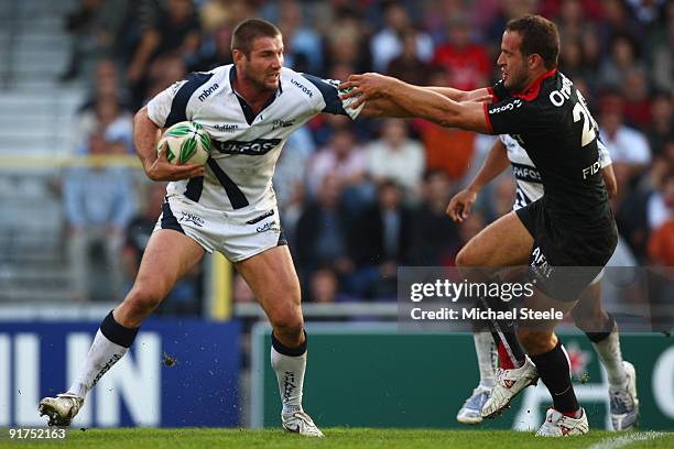 Ben Cohen of Sale holds off Frederic Michalak during the Heineken Cup Pool Five match between Toulouse and Sale Sharks at the Stade Municipial on...