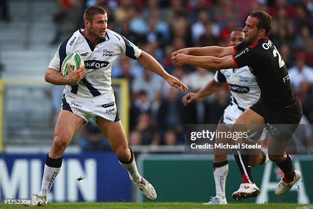 Ben Cohen of Sale holds off Frederic Michalak during the Heineken Cup Pool Five match between Toulouse and Sale Sharks at the Stade Municipial on...