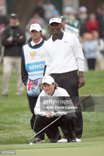 Tim Clark of South Africa and the International Team lines up a birdie putt at the 18th hole in his match with Vijay Singh against Mickelson and...