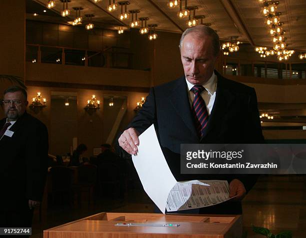 Russian Prime Minister Vladimir Putin posts his ballot into a ballot box at a polling station during municipal elections on October 11, 2009 in...