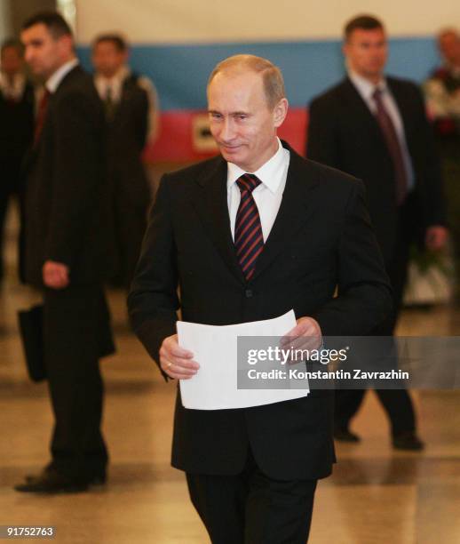 Russian Prime Minister Vladimir Putin prepares to post his ballot at a polling station during municipal elections on October 11, 2009 in Moscow,...