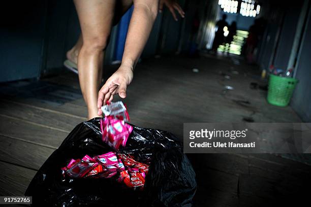 Officers monitor condoms usage by collecting wrappers used by sex workers in a brothel on October 3, 2009 in Merauke, West Papua near Jayapura,...