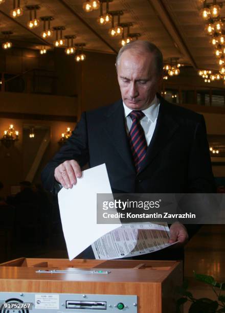 Russian Prime Minister Vladimir Putin posts his ballot into a scanner at a polling station during municipal elections on October 11, 2009 in Moscow,...