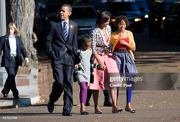 President Barack Obama, daughter Sasha Obama, first lady Michelle Obama, and daughter Malia Obama walk across Pennsylvania Avenue as they return from...