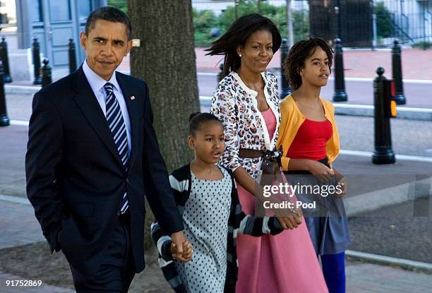 President Barack Obama, daughter Sasha Obama, first lady Michelle Obama, and daughter Malia Obama walk across Pennsylvania Avenue as they return from...