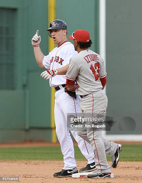 Drew of the Boston Red Sox gestures that he hit a home run in the fourth inning as Maicer Izturis of the Los Angeles Angels of Anaheim applies the...