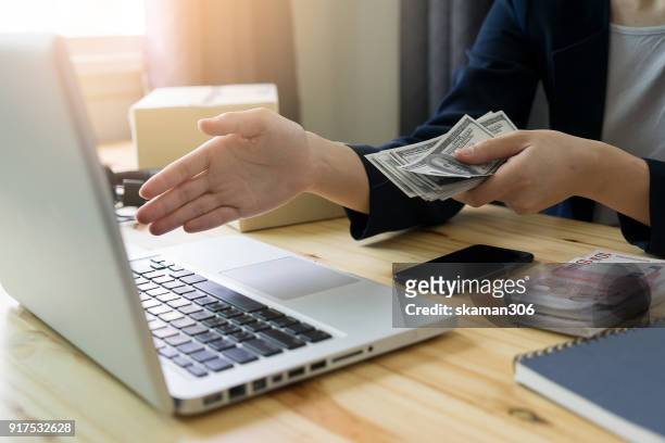 business man shake hand after agree deal with us dollar money in his hand over workspace - true crime stock pictures, royalty-free photos & images