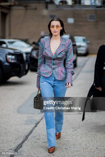 Model Bella Hadid wearing denim jeans, striped blazer jeans, sunglasses seen outside Ralph Lauren on February 12, 2018 in New York City.