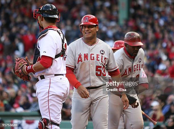 Bobby Abreu of the Los Angeles Angels of Anaheim and Vladimir Guerrero walk by catcher Victor Martinez after scoring on a RBI single by Juan...