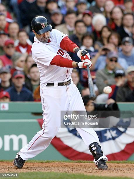 Mike Lowell of the Boston Red Sox hits a RBI single in the eighth inning against the Los Angeles Angels of Anaheim in Game Three of the ALDS during...