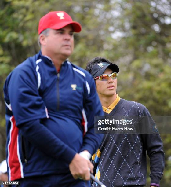 Ryo Ishikawa of the International Team watches the tee shot of Kenny Perry on the third hole during the Day Four Singles Matches of The Presidents...