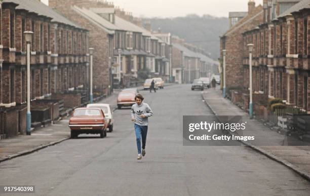 Track Athlete Brendan Foster pictured running through a terraced street during a training run circa 1977 in Gateshead, England.