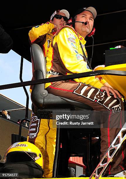 Kyle Busch watches from his pit box after being relieved by David Gilliland in the M&M's Toyota during the NASCAR Sprint Cup Series Pepsi 500 at Auto...