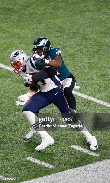 Rob Gronkowski of the New England Patriots makes a reception as Corey Graham of the Philadelphia Eagles tackles him in Super Bowl LII at U.S. Bank...