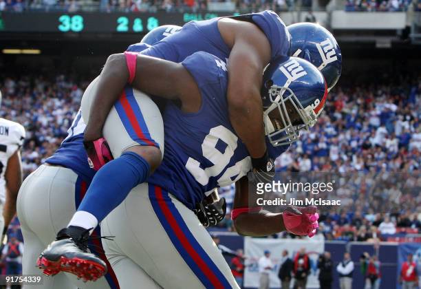 Mathias Kiwanuka of the New York Giants celebrates after forcing a fumble against the Oakland Raiders with teammate Osi Umenyiora on October 11, 2009...