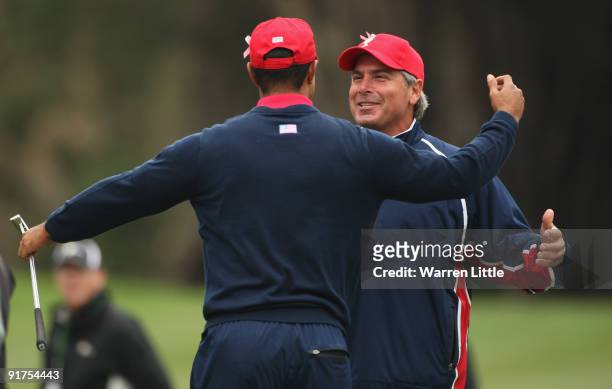 Fred Couples, Captain of the USA Team rushes to congratulate Tiger Woods after winning his Singles Match against Y. E. Yang of the International Team...
