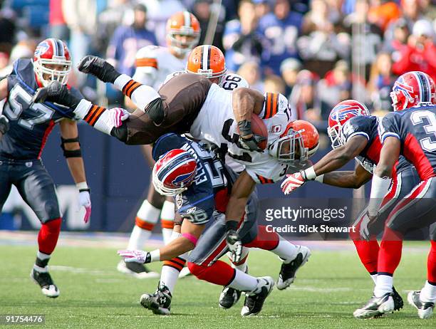 Jamal Lewis of the Cleveland Browns tries to jump over Keith Ellison of the Buffalo Bills at Ralph Wilson Stadium on October 11, 2009 in Orchard...