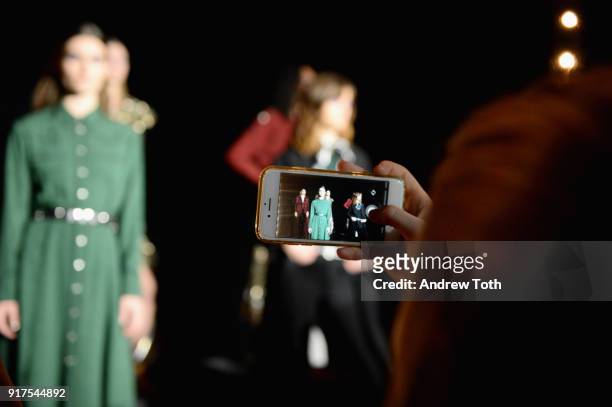 Guest takes of picture of the model on the runway for the Veronica Beard Fall 2018 presentation at Highline Stages on February 12, 2018 in New York...