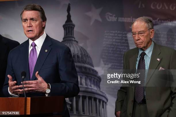 Sen. David Perdue speaks as Sen. Chuck Grassley looks on during a news conference on immigration February 12, 2018 at the Capitol in Washington, DC....