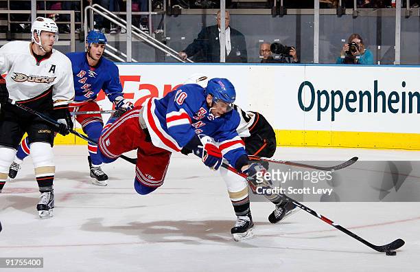 Marian Gaborik of the New York Rangers flies through the air in pursuit of the puck against Scott Niedermayer of the Anaheim Ducks on October 11,...