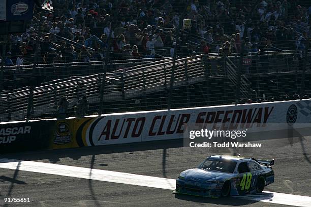 Jimmie Johnson, driver of the Lowe's Chevrolet, crosses the finish line to win the NASCAR Sprint Cup Series Pepsi 500 at Auto Club Speedway on...