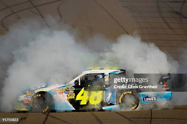 Jimmie Johnson, driver of the Lowe's Chevrolet, performs a burnout to celebrate winning the NASCAR Sprint Cup Series Pepsi 500 at Auto Club Speedway...